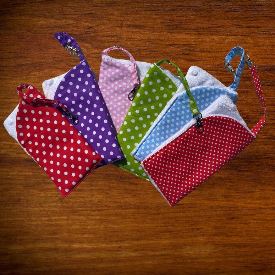 A soft padded glasses case in polka dot cotton and soft white velour lining. The glasses case also benefits from a lobster clip and key ring to fix to a bag strap, belt loop or just to hook.